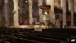 Archbishop Timothy Dolan delivers his homily over empty pews as he leads an Easter Mass at St. Patrick's Cathedral in New York, Sunday, April 12, 2020.