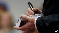 President Donald Trump, visiting areas in Alabama hit by severe storms, signs a Bible as he greets people at Providence Baptist Church in Smiths Station, Ala., March 8, 2019. 
