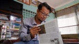 Cambodian journalist Mech Dara looks at newspaper clippings at his home in Phnom Penh on Nov. 5, 2024. A high-profile Cambodian reporter who won an international award for uncovering scam centers, Dara told AFP that he is quitting journalism after a recent arrest. 