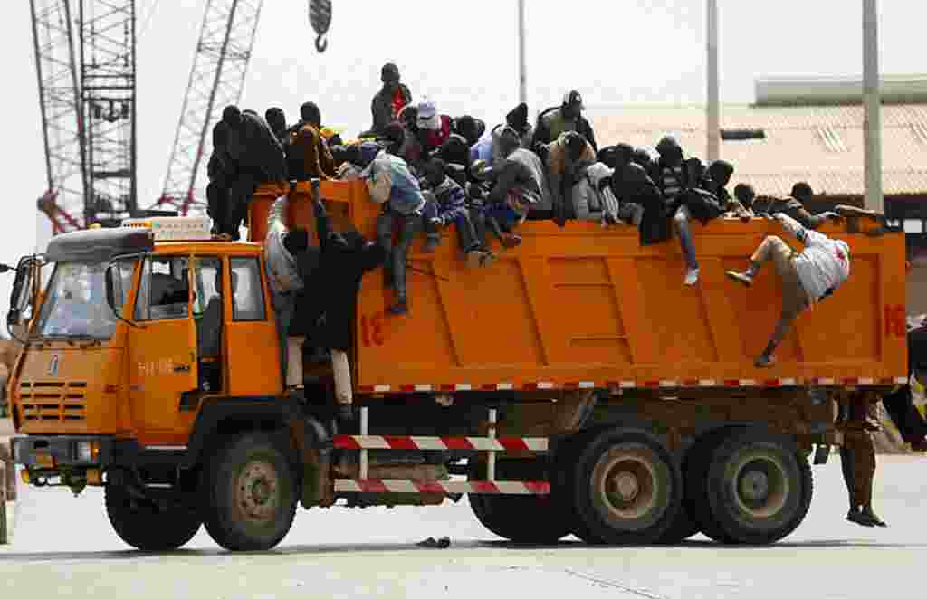 Los trabajadores migrantes de África saltan de un camión después de llegar al puerto de Misrata, durante una operación de evacuación organizada por la OIM (Organización Internacional para las Migraciones), 23 de abril de 2011.