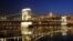 FILE - Ice-floes float under the floodlit Chain Bridge and the Royal Palace in the Castle of Buda in Budapest, Hungary.