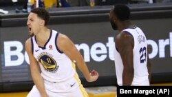 Klay Thompson, à gauche, explose de joie avec son coéquipier Draymond Green, Oakland, Californie, le 26 mai 2018.