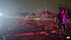 This image provided by Sean Taylor shows an unidentified person talking to firefighters after a tornado hit the area in Midwest City, Okla,, Nov. 3, 2024. (Sean Taylor via AP)