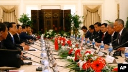 China's Premier Li Keqiang, second left, and Singapore's Prime Minister Lee Hsien Loong, right, attend a meeting with their respective delegations at the Istana or presidential building in Singapore, Nov. 12, 2018.