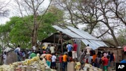 FILE - People gather around a collapsed mine in Chegutu about 100 kilometres (60 miles) west of the capital Harare, Saturday, Sept, 30, 2023. 