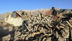 Warga berdiri di tengah rumah-rumah yang rusak akibat gempa bumi di Desa Tonglai, Kecamatan Changsuo, Dingri, Xigaze, Daerah Otonomi Tibet, China barat daya pada Selasa, 7 Januari 2025. (Xinhua via AP)