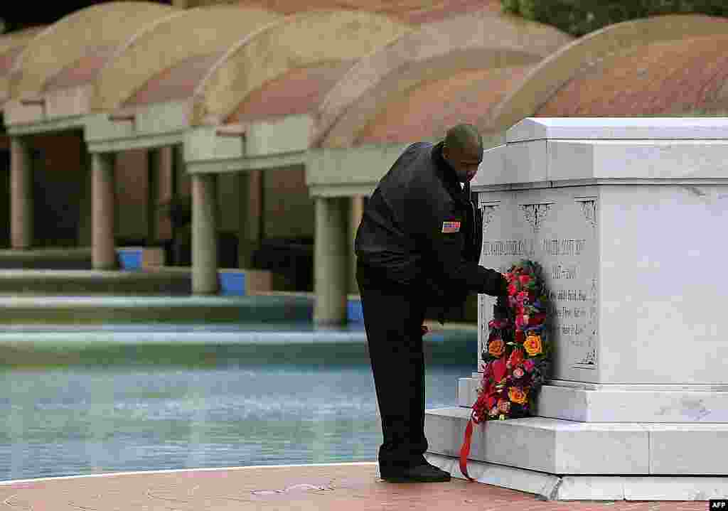 Martin Luther King Jr. Center for Nonviolent Social Change security officer Kevin Baxter places a wreath at the crypts of Martin Luther King Jr., and his wife Coretta Scott King, in Atlanta, Georgia, January 16, 2012. (AP)