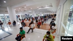 People wait in Sitra Mall to get vaccination against the COVID-19 in Sitra, Bahrain, March 23, 2021. 