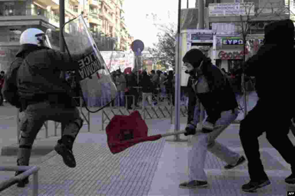 Protesters clash with a riot police officer during a protest in the northern port city of Thessaloniki, Greece, Wednesday, Dec. 15, 2010. At least 10 people were detained Wednesday and five were hurt, including a conservative politician who was beaten in 