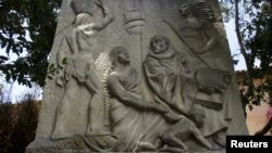 A relief sculpture depicts Father Junipero Serra with Native Americans at the Carmel Mission in Carmel, California, May 5, 2015. 