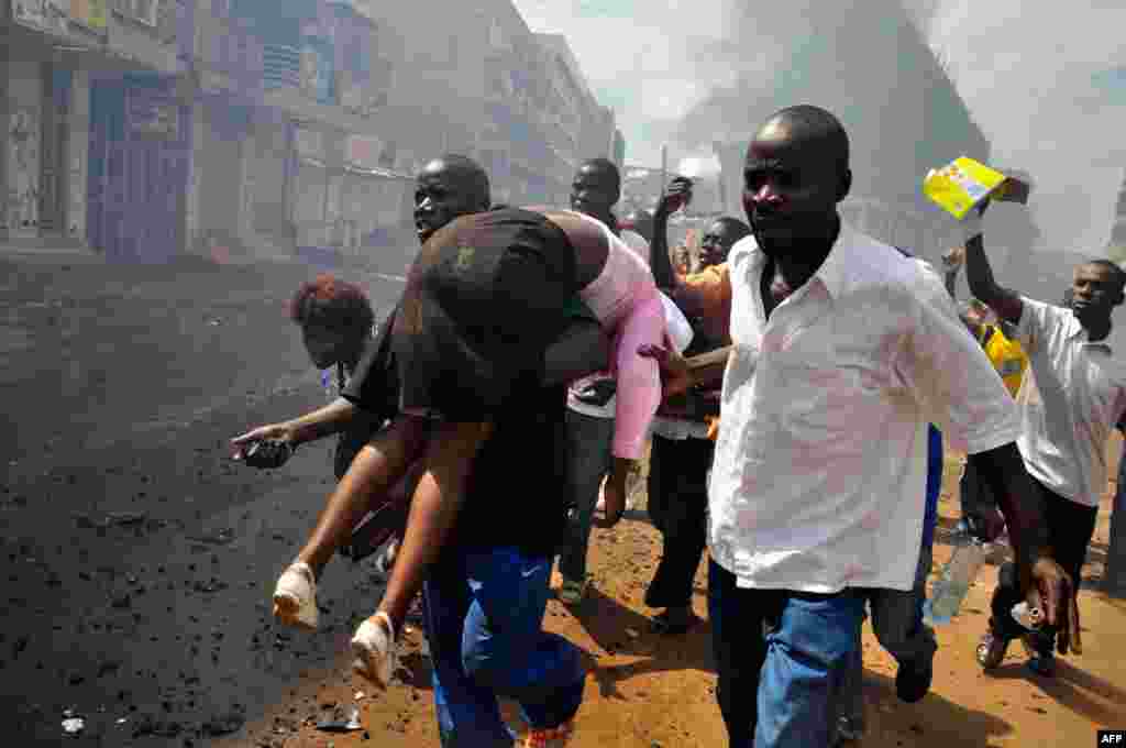 April 29: People carry an injured protester, shot by Ugandan military forces, in Kampala. Ugandan police fired live bullets and tear gas on Friday to disperse crowds protesting the arrest of opposition leader Kizza Besigye. (REUTERS/James Akena)