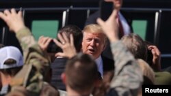 El presidente de EE.UU., Donald Trump, interactúa con una multitud reunida para saludarlo, cuando llega a Colorado para pronunciar el discurso de graduación de la Academia de la Fuerza Aérea. 