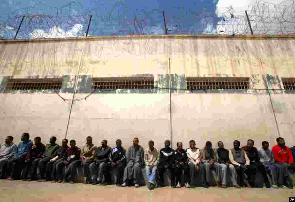 March 24: Mercenaries and forces loyal to Libyan leader Muammar Gaddafi sit inside a prison in Benghazi. (Reuters)