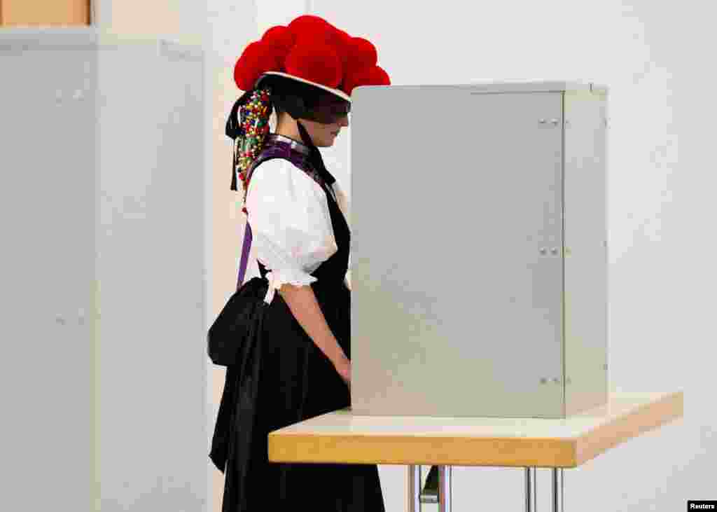 A woman wears the traditional Black Forest costume as she votes in Gutach, Black Forest, Germany.