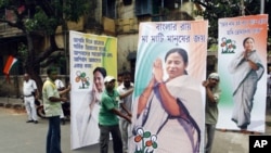 Supporters of the Trinamool Congress party, an ally to India's the ruling Congress Party, hold election billboards featuring portraits of party leader Mamata Banerjee in Kolkata, India, May 13, 2011.