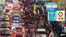 2024年12月4日，参加反对韩国总统尹锡悦游行的抗议者前往首尔总统府。(法新社）