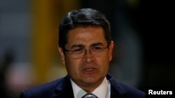 FILE - Honduran President Juan Orlando Hernandez speaks to reporters at Mariscal Sucre Airport in Quito, Ecuador, May 23, 2017, ahead of Ecuador's presidential inauguration.