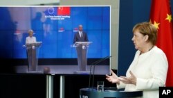 German Chancellor Angela Merkel, right, speaks as she holds a video news conference with European Council President Charles Michel, right on screen, and European Commission President Ursula von der Leyen, in Berlin, Sept. 14, 2020. 