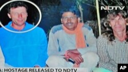 In this television shot of an undated photograph broadcast on Indian news channel NDTV on March 25, 2012, Italian national Claudio Colangelo (L) is seen pictured with fellow Italian national Paolo Bosusco (R), who continues to be held hostage by his capt