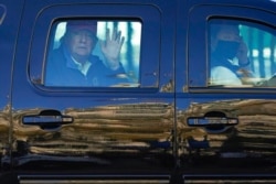 FILE - President Donald Trump waves to supporters from his motorcade as people gather for a march in Washington, Nov. 14, 2020.
