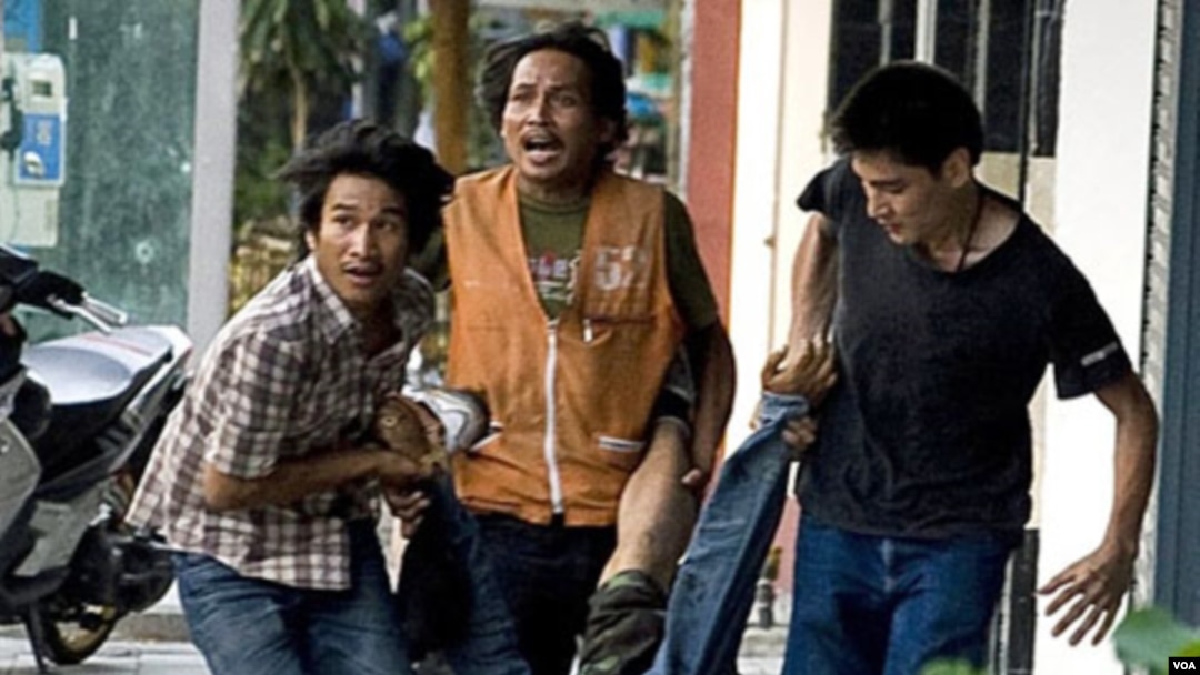 Demonstran Kaos Merah tampak membawa seorang yang terkena tembakan oleh penembak tersembunyi di Bangkok, 15 Mei 2010.