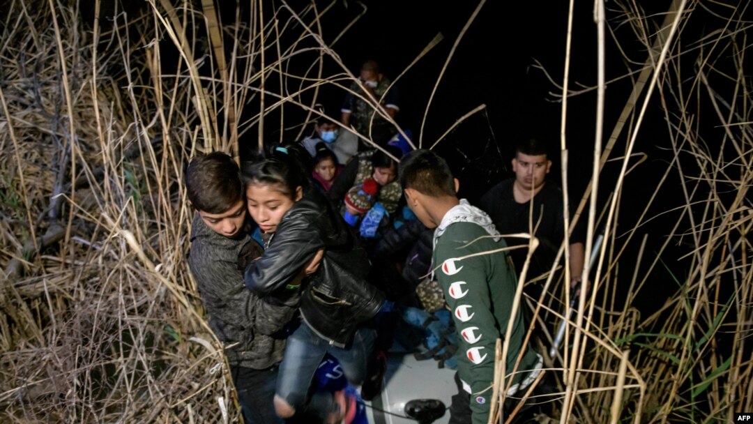 Inmigrantes de Honduras y Guatemala que llegan ilegalmente desde México desembarcan de un bote inflable en el lado estadounidense del río Grande antes de solicitar asilo y entregarse a los agentes de la patrulla fronteriza, el 28 de marzo de 2021. 