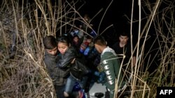 Inmigrantes de Honduras y Guatemala que llegan ilegalmente desde México desembarcan de un bote inflable en el lado estadounidense del río Grande antes de solicitar asilo y entregarse a los agentes de la patrulla fronteriza, el 28 de marzo de 2021. 