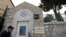 FILE - A man walks past a wall with plaques bearing the words "Embassy United States of America" at the premises of the former U.S. Consulate in Jerusalem, March 12, 2019.