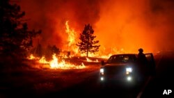 Las llamas arden mientras el incendio Park salta la autopista 36 cerca de Paynes Creek en el condado de Tehama, California, el viernes 26 de julio de 2024.