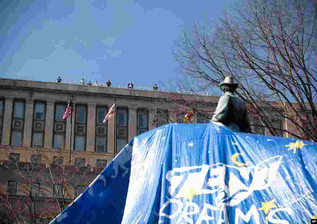 People watch from the roof of a nearby building. (Alison Klein/VOA)