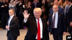 President-elect Donald Trump waves to the crowd as he leaves the New York Times building following a meeting, Nov. 22, 2016, in New York.