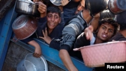 Sejumlah warga Palestina berdesak-desakan saat mengantre untuk mendapatkan makanan di sebuah dapur umum di Khan Younis, Jalur Gaza, pada 4 Desember 2024. (Foto: Reuters/Mohammed Salem)