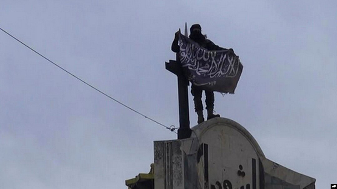 Gambar yang dipasang di akun Twitter Front al-Nusra menunjukkan seorang pejuang kelompok afiliasi al-Qaida itu mengibarkan bendera di provinsi Idlib (28/3).
