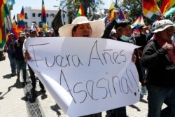 A supporter of former President Evo Morales carries a sign reading in Spanish "Out, Anez. Murderer" referring to interim president Jeanine Anez during a protest in Cochabamba, Bolivia, Nov. 18, 2019.