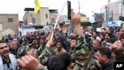 FILE - Protesters shout slogans and brandish weapons during a demonstration calling for the immediate withdrawal of Turkish troops from northern Iraq, in Basra, Iraq.