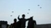 Люди у Газі спостерігають, як американські військові десантують допомогу з літаків на тлі війни між Ізраїлем і палестинським угрупованням ХАМАС, 2 березня 2024 р. REUTERS/Kosay Al Nemer
