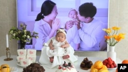 In this April 9, 2019, photo, Lee Dong Kil's daughter Lee Yoon Seol sits to celebrate her 100th day of the birth at Lee's house in Daejeon, South Korea. Just two hours after Lee’s daughter was born on New Year’s Eve, the clock struck midnight. (AP Photo/Ahn Young-joon)