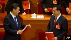 Chinese President Xi Jinping, left, and Chinese Premier Li Keqiang prepare to leave after the closing ceremony of the National People's Congress in Beijing's Great Hall of the People, March 15, 2015. 