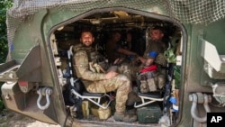 Ukrainian soldiers sit inside their armored personnel carrier after returning from Russia's Kursk region, near the border in the Sumy region of Ukraine on Aug. 14, 2024.