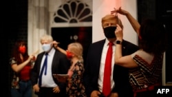 Artists put the finishing touches to wax figures Britain's Prime Minister Boris Johnson and US President Donald Trump as Madame Tussauds prepares to reopen its doors to the public on July 30, 2020.