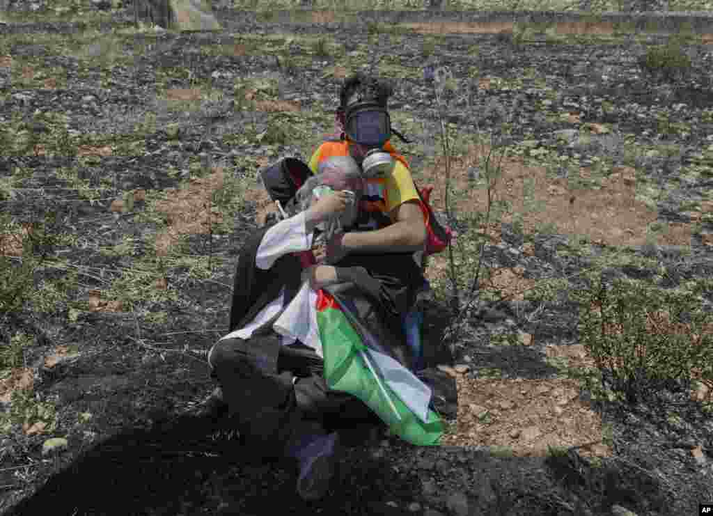 A medical worker helps a priest, who was taking part in a rally against the American-led Mideast peace conference, after Israeli border police dispersed Palestinian protesters with tear gas, near the settlement of Beit El, at the outskirts of the West Bank.