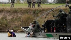 FILE - A U.S. border patrol boat rescues migrants crossing the Rio Bravo toward the United States, seen from Piedras Negras, Mexico, Feb. 10, 2019. 