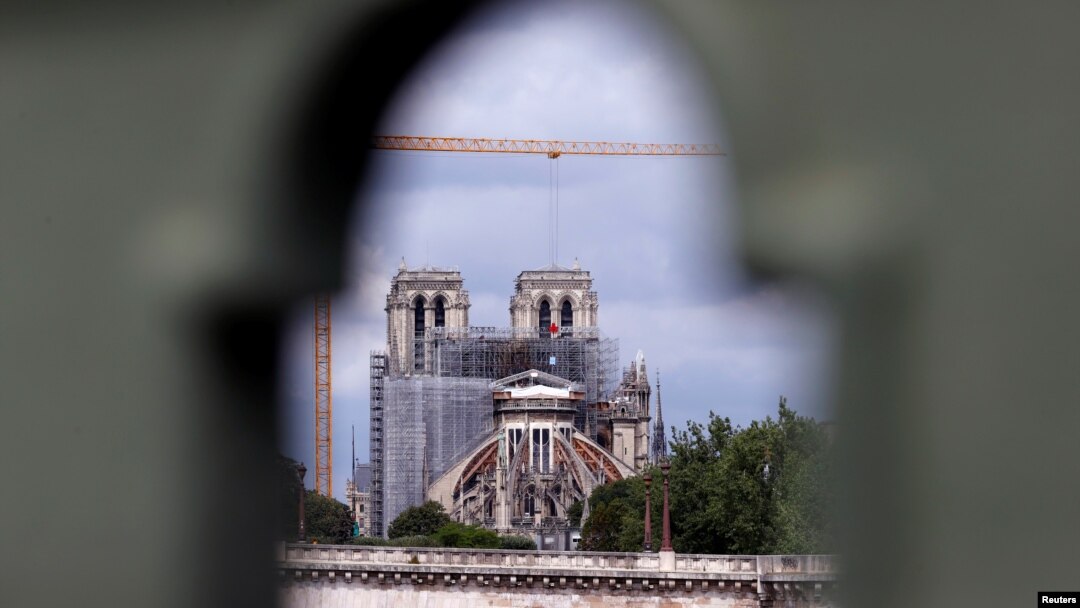 Para pekerja mulai menyingkirkan besi perancah di Gereja Katedral Notre Dame yang terbakar tahun lalu dan memulai pekerjaan restorasi, di Paris, 8 Juni 2020. 