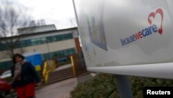 Seorang perempuan meninggalkan Rumah Sakit Stafford di Inggris tengah (6/2). (Reuters/Darren Staples)