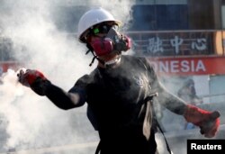 A protester throws a tear gas canister back at the police during a demonstration in support of the city-wide strike and to call for democratic reforms in Hong Kong, China, Aug. 5, 2019.