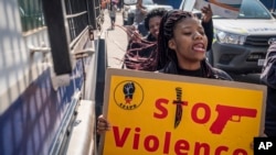 Women protest outside the Krugersdorp, South Africa, Magistrates Court Monday, Aug. 1, 2022