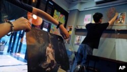 Employees remove stickers and posters with messages in support of the pro-democracy movement at a restaurant in Hong Kong, July 2, 2020. 