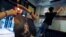 Employees remove stickers and posters with messages in support of the pro-democracy movement at a restaurant in Hong Kong, July 2, 2020. 