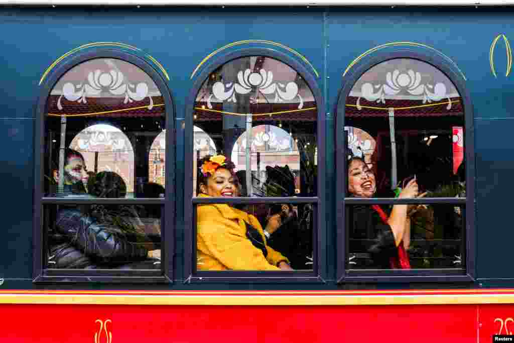 Women sit on a trolley as the Mexican-American community of Pilsen celebrates Day of the Dead with multiple celebrations through their neighborhood in Chicago, Illinois, Nov. 2, 2019.