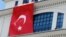 A Turkish flag is hung from the headquarters of Turkish Prime Minister Recep Tayyip Erdogan’s ruling party, apparently to conceal damage after assailants fired a rocket on the building, in Ankara, March 20, 2013.